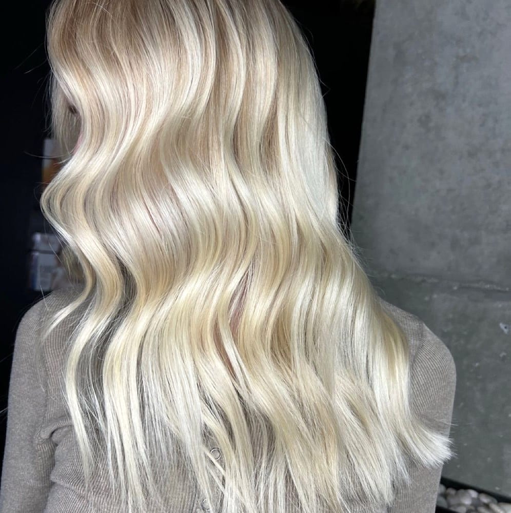 Back view of wavy platinum blonde hair in the salon